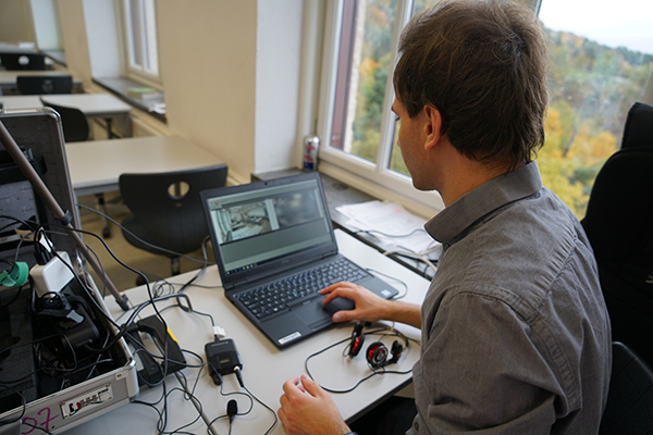 Ruben Bredal sitter ved et bord og jobber på en PC