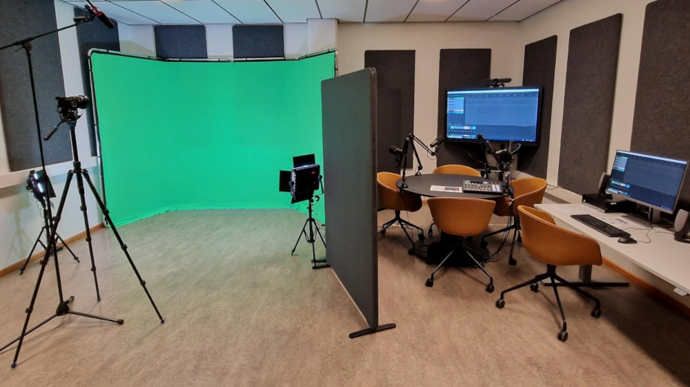 A green screen and a podcasting station inside the U29 media produciton studio.